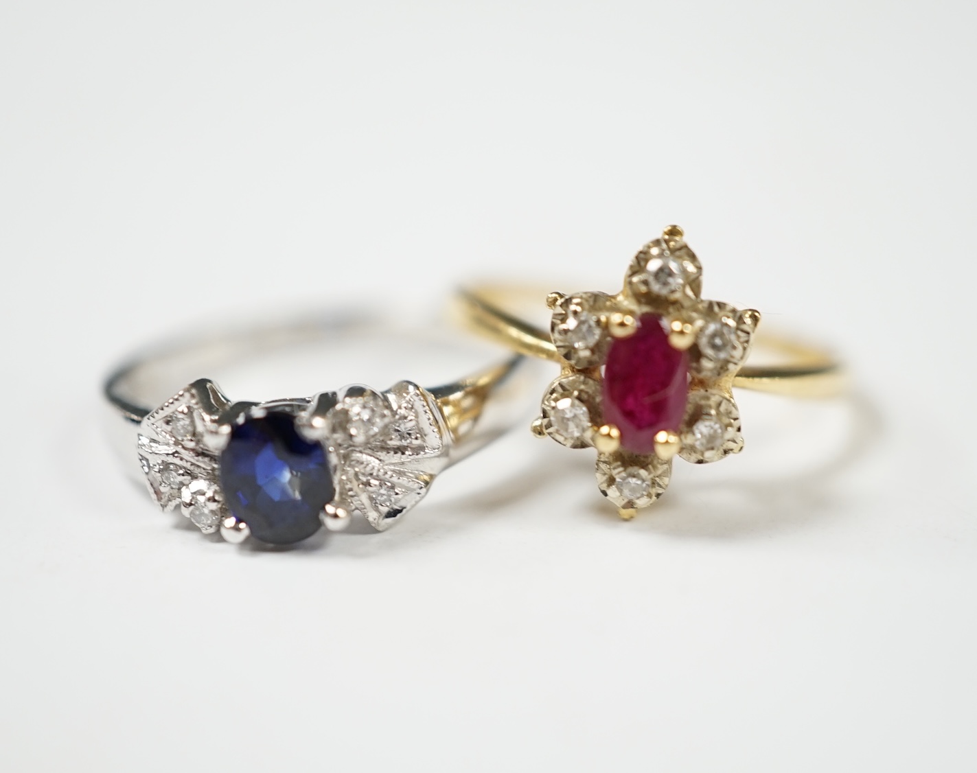 A French 18k, ruby and diamond set flower head cluster ring, size J and an 18k white metal, sapphire and diamond chip set ring, gross weight 4.8 grams. Condition - fair